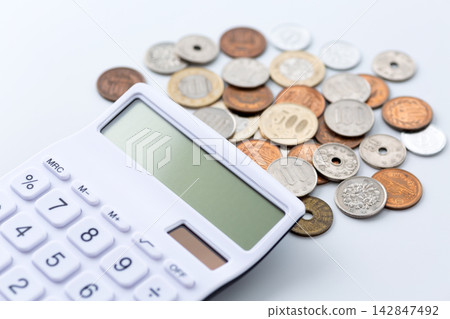 硬幣和一台白色計算器 硬幣和一台白色計算器 142847492