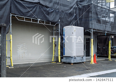 Temporary toilets placed at the entrance of a building undergoing exterior construction. Temporary toilets placed at the entrance of a building undergoing exterior construction. 142847511