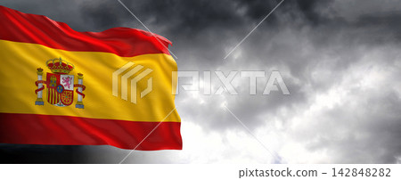 Spain Flag Waving Against Dark Cloudy Sky Spain Flag Waving Against Dark Cloudy Sky 142848282