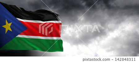 South Sudan Flag Waving Against Dark Cloudy Sky South Sudan Flag Waving Against Dark Cloudy Sky 142848311
