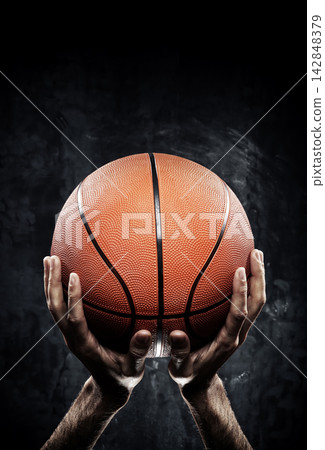 Basketball Held Close-Up with Dramatic Lighting Basketball Held Close-Up with Dramatic Lighting 142848379
