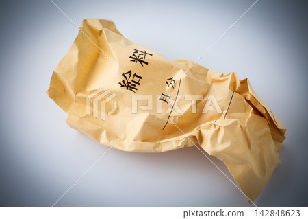 A crumpled pay envelope on a white background. 142848623