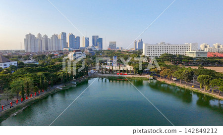 Panoramic view of Danau UNESA lake surrounded by green trees and city skyline in Surabaya East Java. Panoramic view of Danau UNESA lake surrounded by green trees and city skyline in Surabaya East Java. 142849212