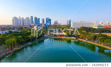 Panoramic view of Danau UNESA lake surrounded by green trees and city skyline in Surabaya East Java. Panoramic view of Danau UNESA lake surrounded by green trees and city skyline in Surabaya East Java. 142849213