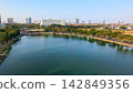 Scenic view of Danau UNESA lake surrounded by green trees and urban skyline in Surabaya, East Java, Indonesia. 142849356