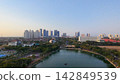 Scenic panoramic view of Danau UNESA lake surrounded by green trees and city skyline in Surabaya, East Java, Indonesia. 142849539