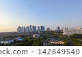 Scenic panoramic view of Danau UNESA lake surrounded by green trees and city skyline in Surabaya, East Java, Indonesia. 142849540