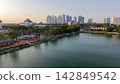 Scenic panoramic view of Danau UNESA lake surrounded by green trees and city skyline in Surabaya, East Java, Indonesia. 142849542