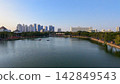 Scenic panoramic view of Danau UNESA lake surrounded by green trees and city skyline in Surabaya, East Java, Indonesia. 142849543