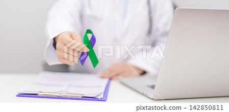 Doctor giving purple and green ribbon to patient for concept of March Anal Cancer Awareness month, Colorectal and Colon Cancer, Healthcare and February world cancer day 142850811