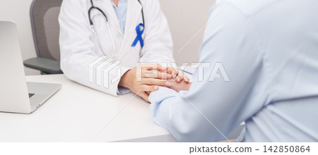 doctor holding patient hand to comfort and support with empathy. Navy blue ribbon concept of March Colorectal and Colon Cancer Awareness month, May Arthritis awareness, July Juvenile arthritis 142850864
