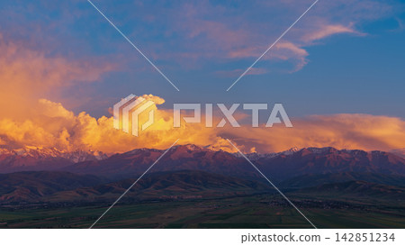 Snow-capped mountain range at sunset with dramatic clouds Snow-capped mountain range at sunset with dramatic clouds 142851234