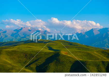 Rolling Green Hills and Snow-Capped Mountains in Kyrgyzstan 142851240