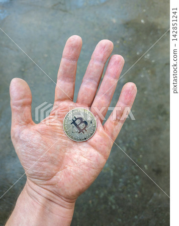 Close-up of Bitcoin Coin Held in Open Palm Close-up of Bitcoin Coin Held in Open Palm 142851241