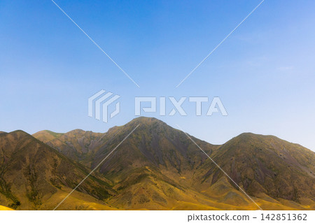 Rugged Mountain Range Under Bright Blue Sky in Kyrgyzstan Rugged Mountain Range Under Bright Blue Sky in Kyrgyzstan 142851362