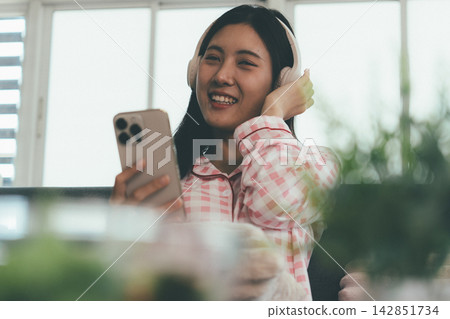 Woman enjoying life at home, promoting healthy eating, wellness, and a balanced lifestyle. Concept of natural nutrition, mindfulness, and modern healthy living. Woman enjoying life at home, promoting healthy eating, wellness, and a balanced lifestyle. Concept of natural nutrition, mindfulness, and modern healthy living. 142851734