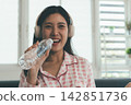 Woman enjoying life at home, promoting healthy eating, wellness, and a balanced lifestyle. Concept of natural nutrition, mindfulness, and modern healthy living. 142851736