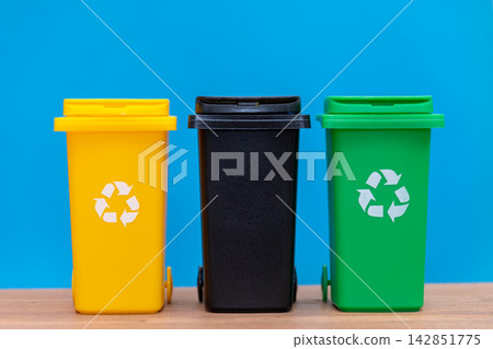 Three colorful recycling bins arranged side by side on blue background Three colorful recycling bins arranged side by side on blue background 142851775