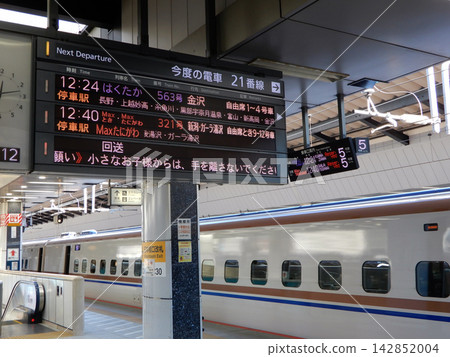 一列北陸新幹線列車停靠東京車站,並顯示出發資訊顯示器。 一列北陸新幹線列車停靠東京車站,並顯示出發資訊顯示器。 142852004