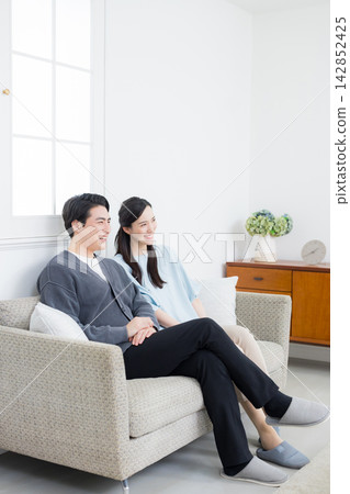 A young couple relaxing in the living room A young couple relaxing in the living room 142852425