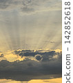 Golden Sunset Rays Piercing Through Storm Clouds 142852618