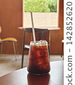 Iced Coffee Glass on Wooden Table in Cozy Cafe 142852620