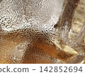 Macro Ice Cube With Golden Drink Reflections 142852694