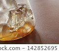 Macro Shot of Ice Cubes in Golden Iced Drink 142852695
