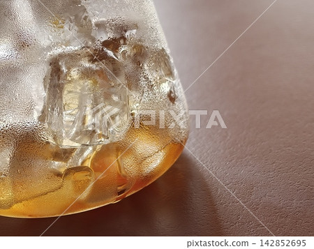 Macro Shot of Ice Cubes in Golden Iced Drink 142852695