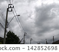 Power Lines and Street Lamp Under Storm Clouds 142852698