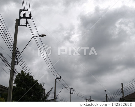 Power Lines and Street Lamp Under Storm Clouds 142852698