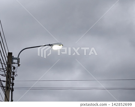 Street Lamp Lit at Dusk Against Cloudy Sky Street Lamp Lit at Dusk Against Cloudy Sky 142852699
