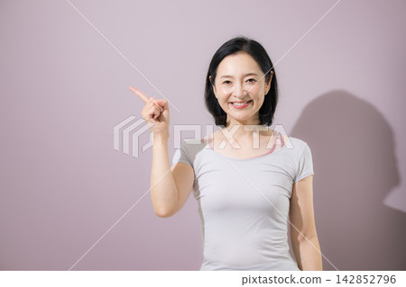 一位日本中年婦女面帶微笑,指指點點,提出建議;一位運動健身教練向顧客推薦產品和服務並進行指導。 一位日本中年婦女面帶微笑,指指點點,提出建議;一位運動健身教練向顧客推薦產品和服務並進行指導。 142852796