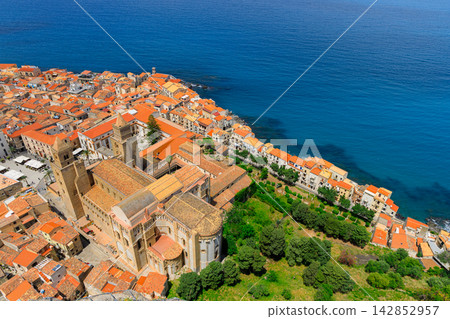 Aerial view of a historic medieval coastal town with a grand cathedral and terracotta rooftops Aerial view of a historic medieval coastal town with a grand cathedral and terracotta rooftops 142852957