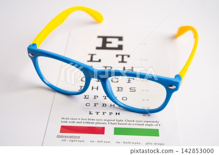 Glasses on eye testing exam chart to check eyesight accuracy of reading. Glasses on eye testing exam chart to check eyesight accuracy of reading. 142853000