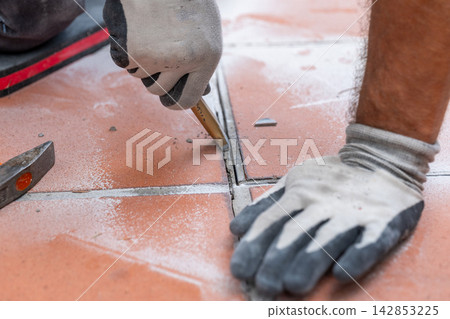 Detailed view of removing old grout and mortar before dismantling the existing ceramic floor covering. Detailed view of removing old grout and mortar before dismantling the existing ceramic floor covering. 142853225