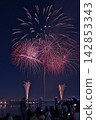 Fireworks soaring into the night sky; fireworks blooming in the summer night sky; fireworks blooming in the night sky; a fireworks display shining brightly; people watching the fireworks. 142853343