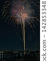 Fireworks soaring into the night sky; fireworks blooming in the summer night sky; fireworks blooming in the night sky; a fireworks display shining brightly; people watching the fireworks. 142853348