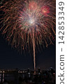 Fireworks soaring into the night sky; fireworks blooming in the summer night sky; fireworks blooming in the night sky; a fireworks display shining brightly; people watching the fireworks. 142853349