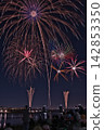 Fireworks soaring into the night sky; fireworks blooming in the summer night sky; fireworks blooming in the night sky; a fireworks display shining brightly; people watching the fireworks. 142853350