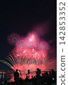 Fireworks soaring into the night sky; fireworks blooming in the summer night sky; fireworks blooming in the night sky; a fireworks display shining brightly; people watching the fireworks. 142853352