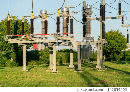Modern high-voltage electrical substation equipment with power lines and insulators in an outdoor energy distribution facility Modern high-voltage electrical substation equipment with power lines and insulators in an outdoor energy distribution facility 142854403