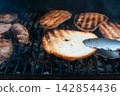 Grilled bread slices over hot coals with tongs Grilled bread slices over hot coals with tongs 142854436