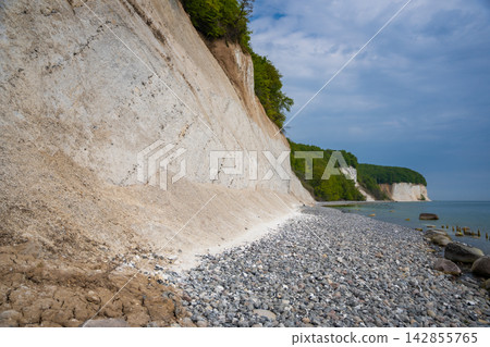 Famous white chalk cliffs and rocky Baltic Sea coastline in Jasmund National Park on Rugen island, Germany. Iconic natural landmark and coastal travel destination concept. 142855765