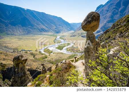 View of Chulyshman valley and river through stone mushrooms in Altai Russia Unique natural landscape with rock formations and flowing water View of Chulyshman valley and river through stone mushrooms in Altai Russia Unique natural landscape with rock formations and flowing water 142855879