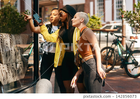 Friends, street and women in city for window shopping for vacation, holiday and travel together on weekend. Happy, fashion and people by shop or retail store in town for bonding, fun and explore Friends, street and women in city for window shopping for vacation, holiday and travel together on weekend. Happy, fashion and people by shop or retail store in town for bonding, fun and explore 142856073
