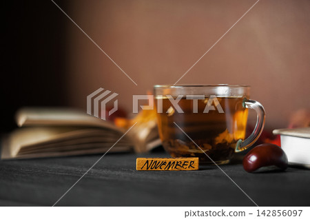 Cozy seasonal still life with hot tea, books and natural autumn decor Cozy seasonal still life with hot tea, books and natural autumn decor 142856097