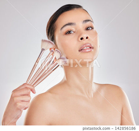 Portrait, brush and girl with cosmetics, confidence and makeup for beauty, tools and aesthetic. White background, foundation and application for concealer, blush and skincare for person Portrait, brush and girl with cosmetics, confidence and makeup for beauty, tools and aesthetic. White background, foundation and application for concealer, blush and skincare for person 142856186