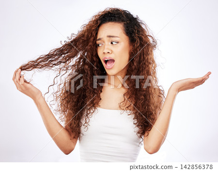 African woman, confused and curly hair in studio with what, why or shocked gesture for damage or frizz. Young person or model with worry for growth, hairstyle and care tips on a white background African woman, confused and curly hair in studio with what, why or shocked gesture for damage or frizz. Young person or model with worry for growth, hairstyle and care tips on a white background 142856378