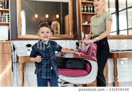 Happy, hairdresser and portrait of child in barbershop for hair care, grooming and beauty. Professional, service and kid smile with pride in salon, store and appointment with woman for hairstyle Happy, hairdresser and portrait of child in barbershop for hair care, grooming and beauty. Professional, service and kid smile with pride in salon, store and appointment with woman for hairstyle 142856548